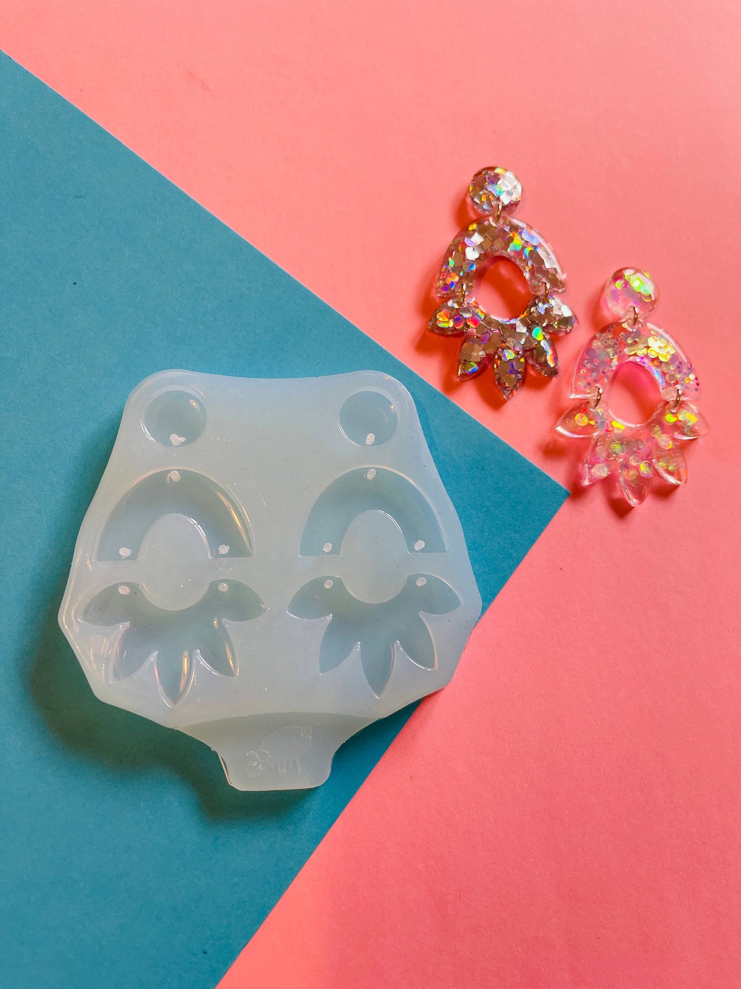 Form for epoxy. A set of earrings in the form of an arc and a flower Silicone mold. Jewelry pendant from a casting mold. Glossy resin mold.