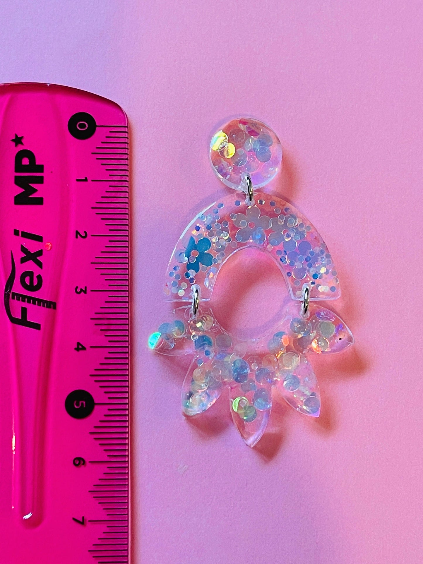 Form for epoxy. A set of earrings in the form of an arc and a flower Silicone mold. Jewelry pendant from a casting mold. Glossy resin mold.